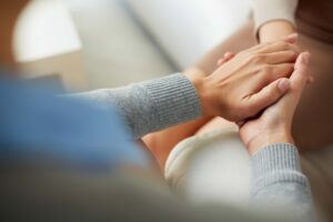 compassionate therapist holding hand of client
